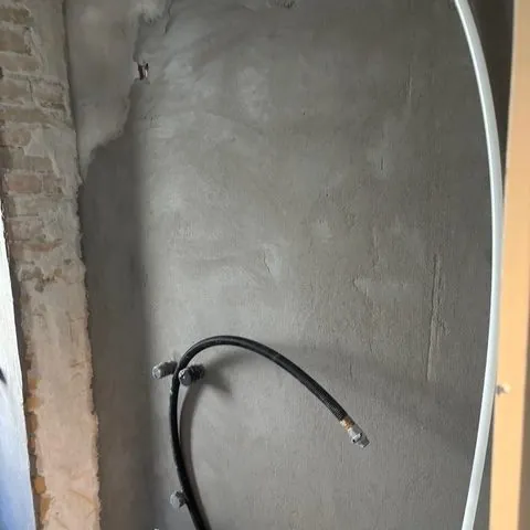 Badeværelsesvæg under renovering med rør trukket frem
